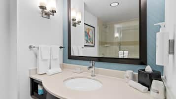 Une salle de bain moderne avec un grand miroir, un lavabo et un porte-serviettes.