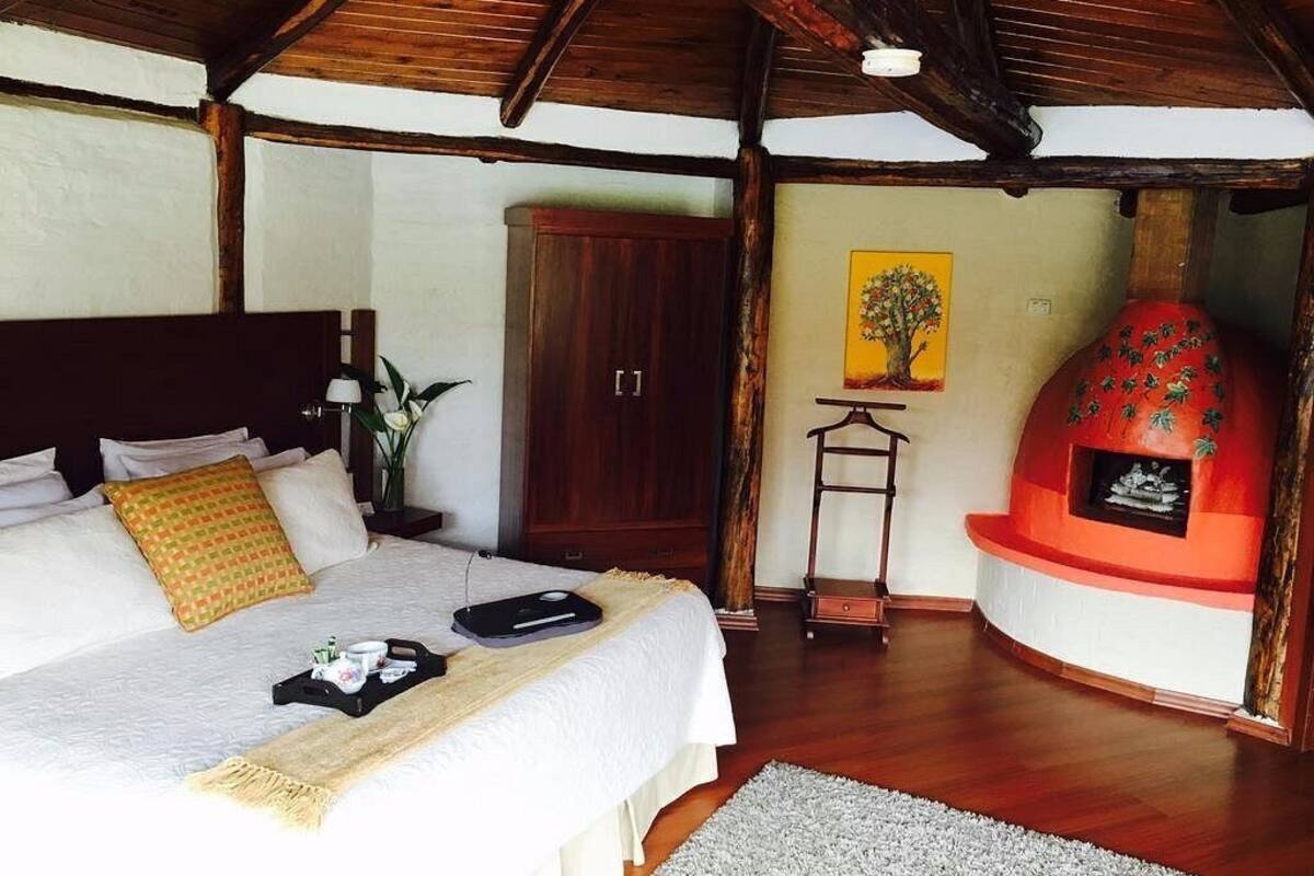 Ein Schlafzimmer mit Bett, Nachttisch und Kamin.