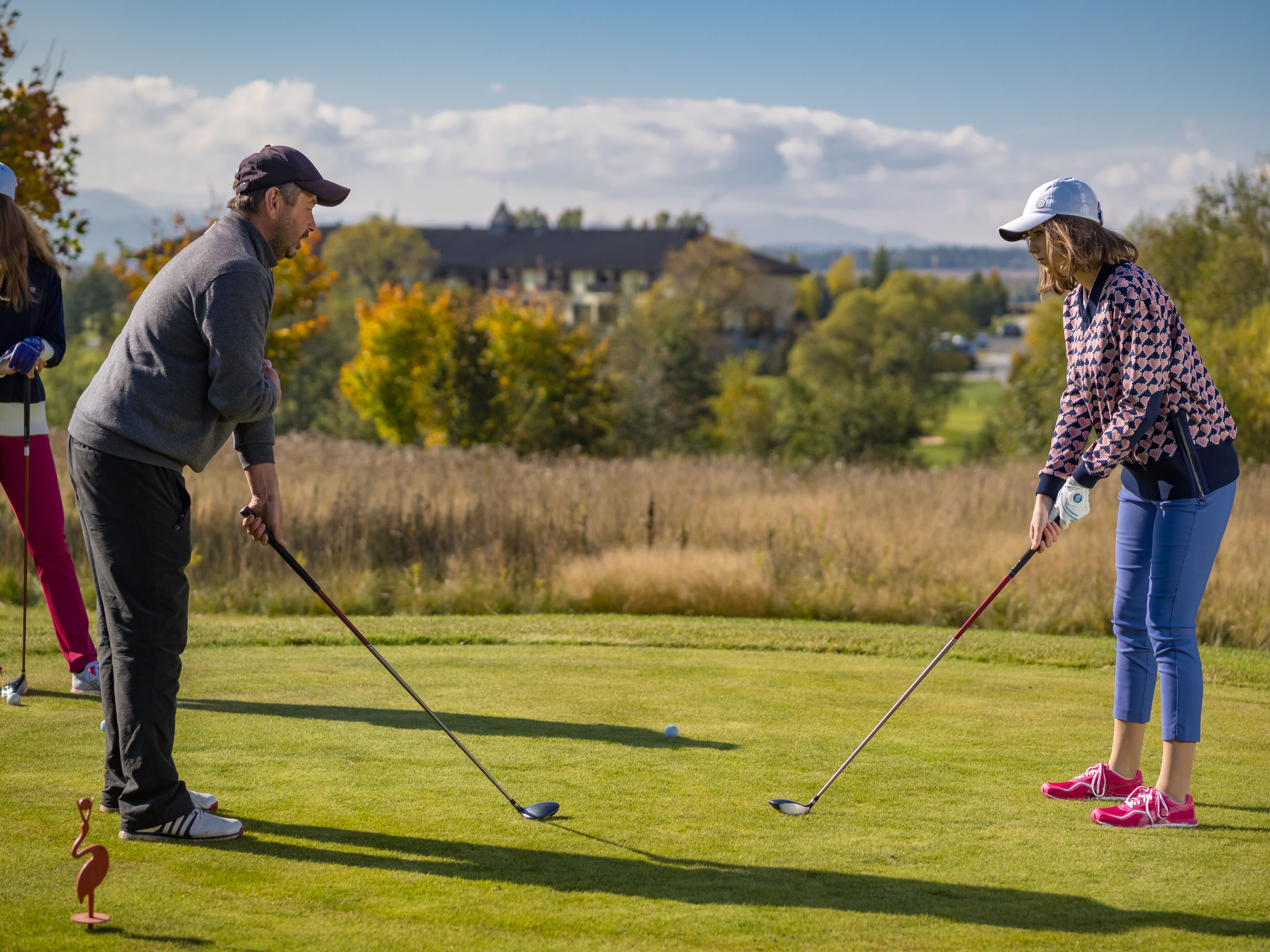 A golf course with players and a putting green.