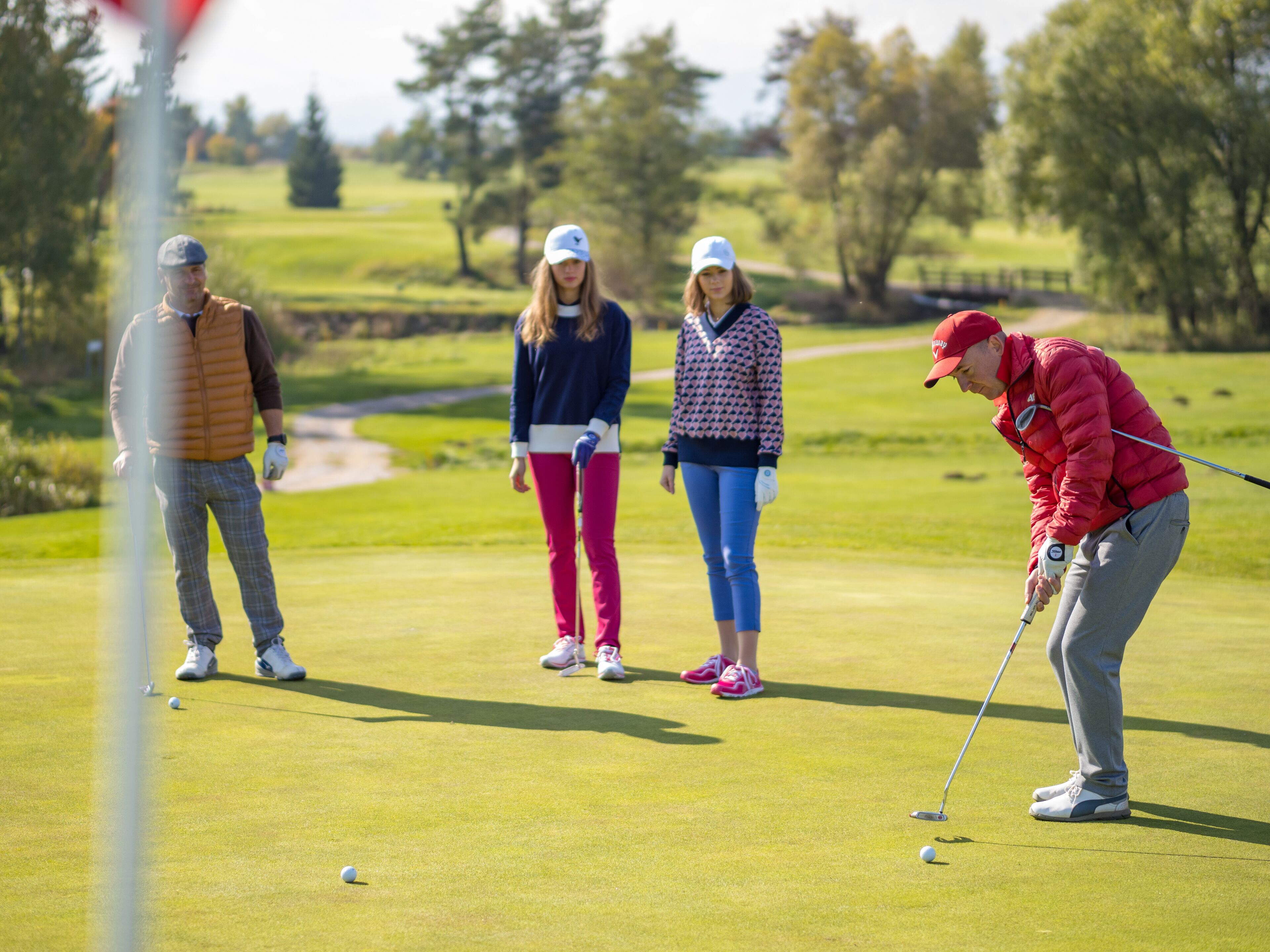 Un parcours de golf avec des joueurs et un green d’entraînement.