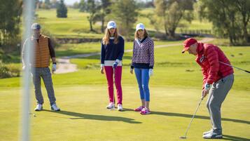 Un parcours de golf avec des joueurs et un green d’entraînement.