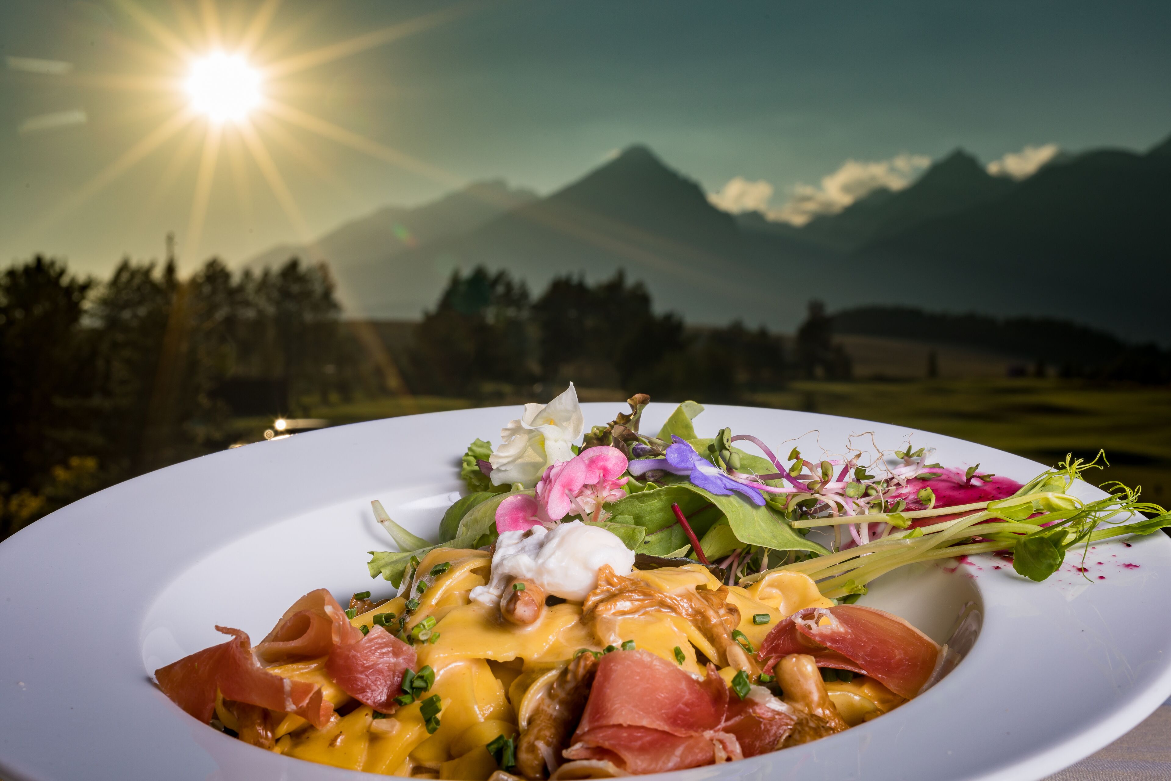 Un plato de comida con un paisaje montañoso al fondo.
