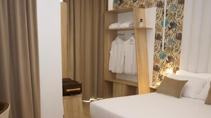 Une chambre à coucher moderne avec un grand lit, une armoire en bois et une petite table.
