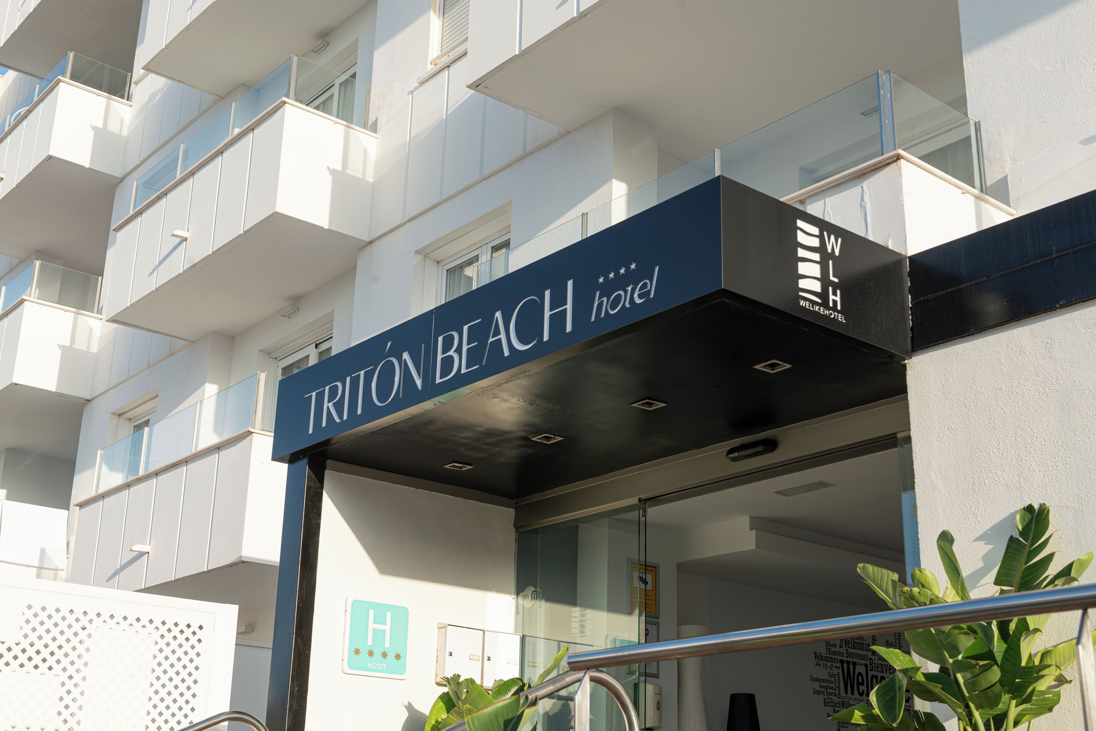 En hotelindgang med et skilt, der viser 'TRITON BEACH hotel'.