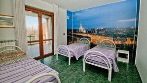 A room with two beds, a large window with a cityscape view, and a sliding door. - Hotel delle Alpi (Turin)