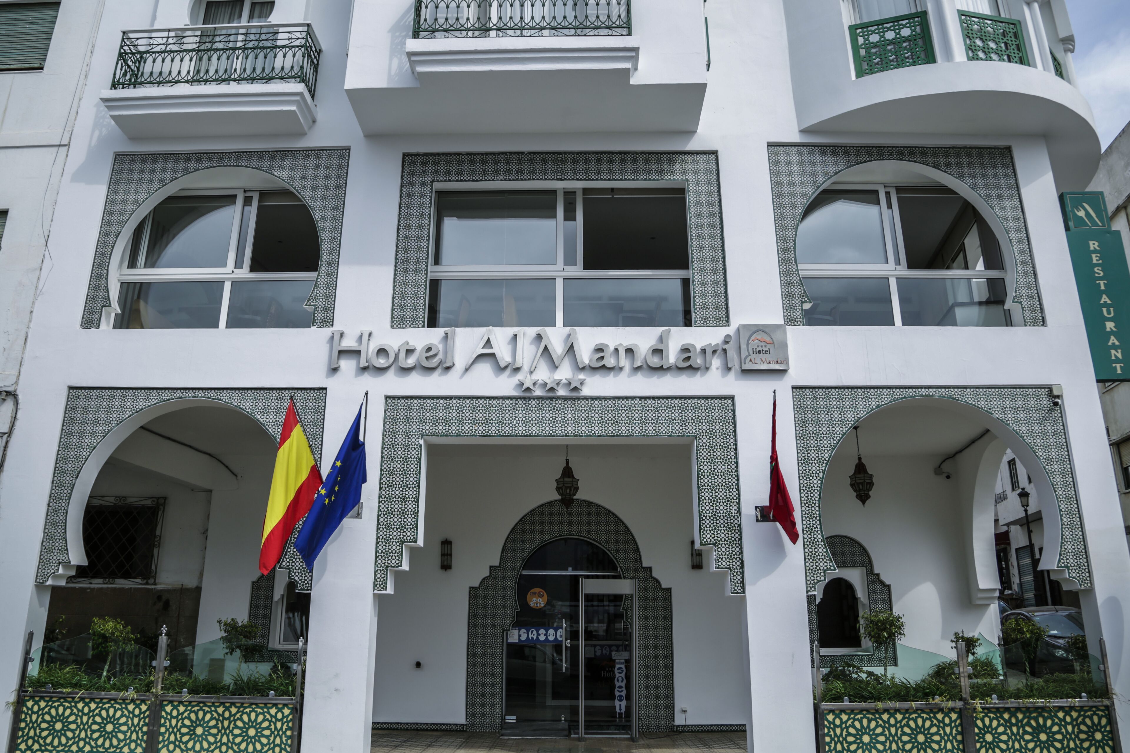 A hotel facade with a sign reading "Hotel Al Mandari".