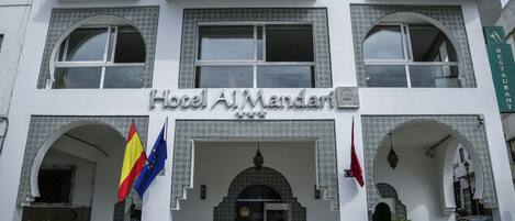 A hotel facade with a sign reading "Hotel Al Mandari".