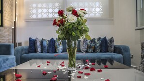 A glass table with a vase of roses and scattered petals. - Hôtel al Mandari (Tetouan)