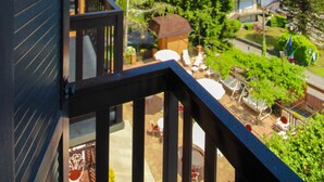 Un balcón de madera con vistas a una zona residencial, con casas y árboles.