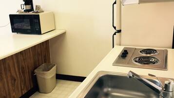 A compact kitchen with a microwave, a sink, and a stove.
