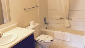 A bathroom with a sink, toilet, and bathtub.