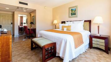 Een hotelkamer met een groot bed, nachtkastjes, een bureau en een stoel.