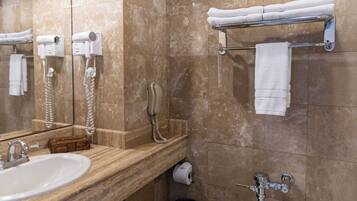 Ein Badezimmer mit Marmorwaschtisch, Toilette, Handtuchhalter und Fön.