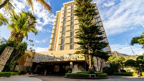 A hotel with a modern facade, a prominent entrance, and surrounding greenery. - Hotel Honduras Maya (Tegucigalpa)