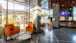 A spacious lobby with large windows, a bar area, and modern furniture. - Hotel Honduras Maya (Tegucigalpa)