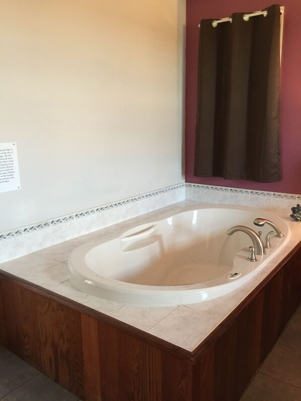 Un baño con una bañera independiente, un tocador de madera y un perchero para toallas.