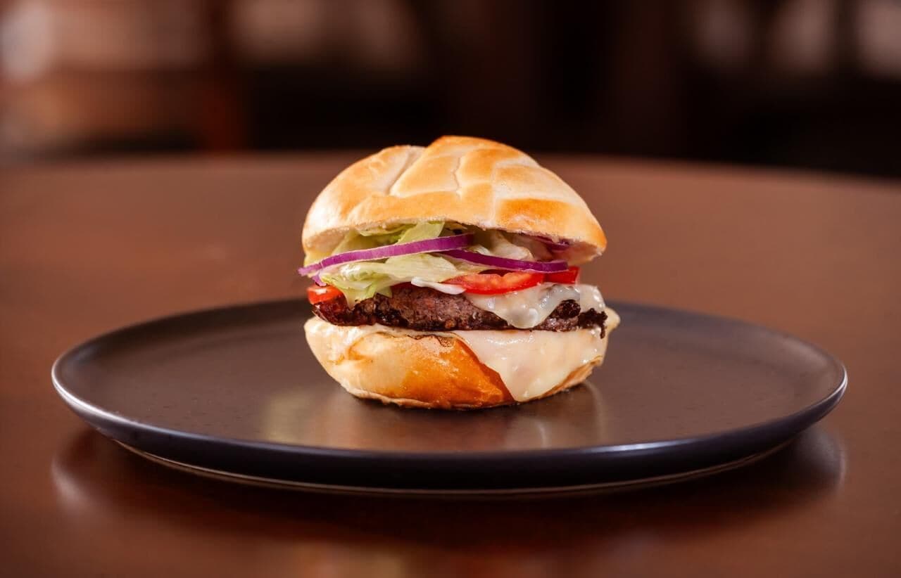 A burger on a dark plate.