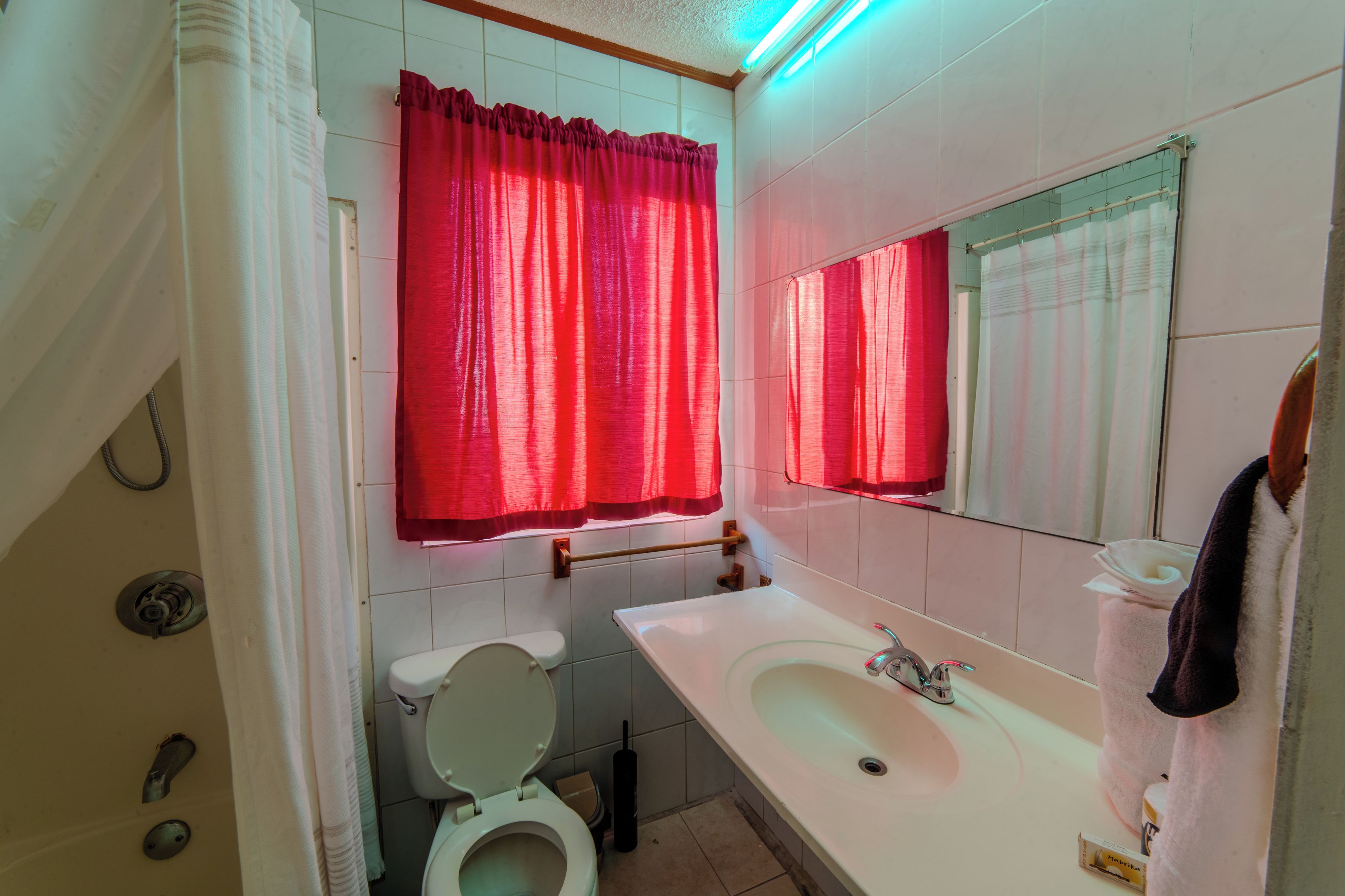Une salle de bain avec des toilettes, un lavabo et un miroir.