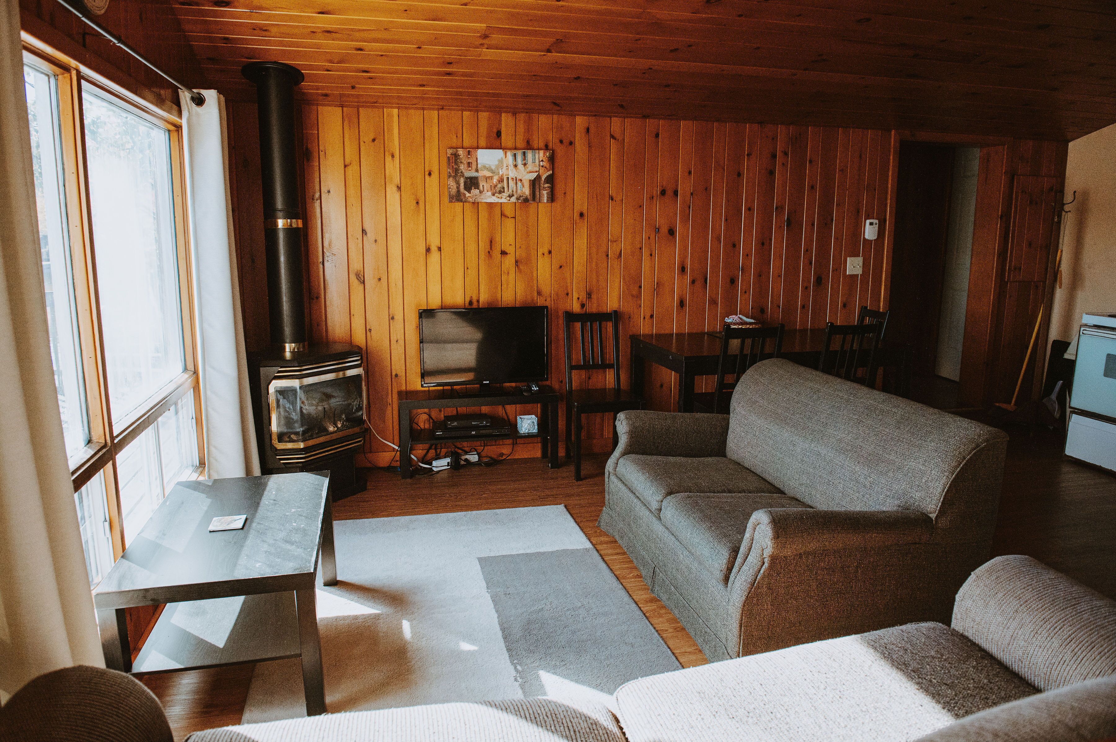 A cozy living room with a fireplace, a television, and a sofa.