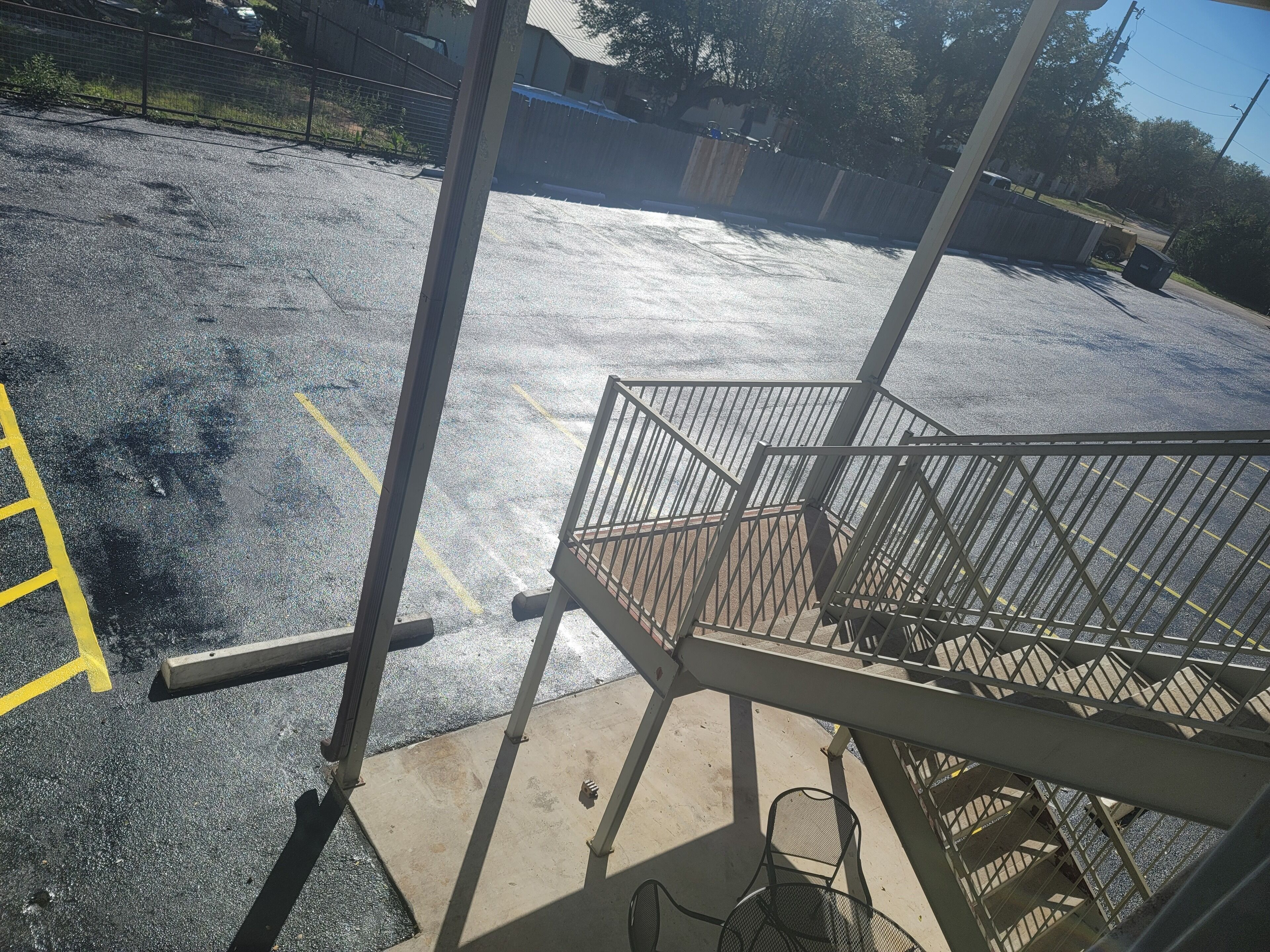 A parking area with a concrete floor and yellow lines marking parking spaces.