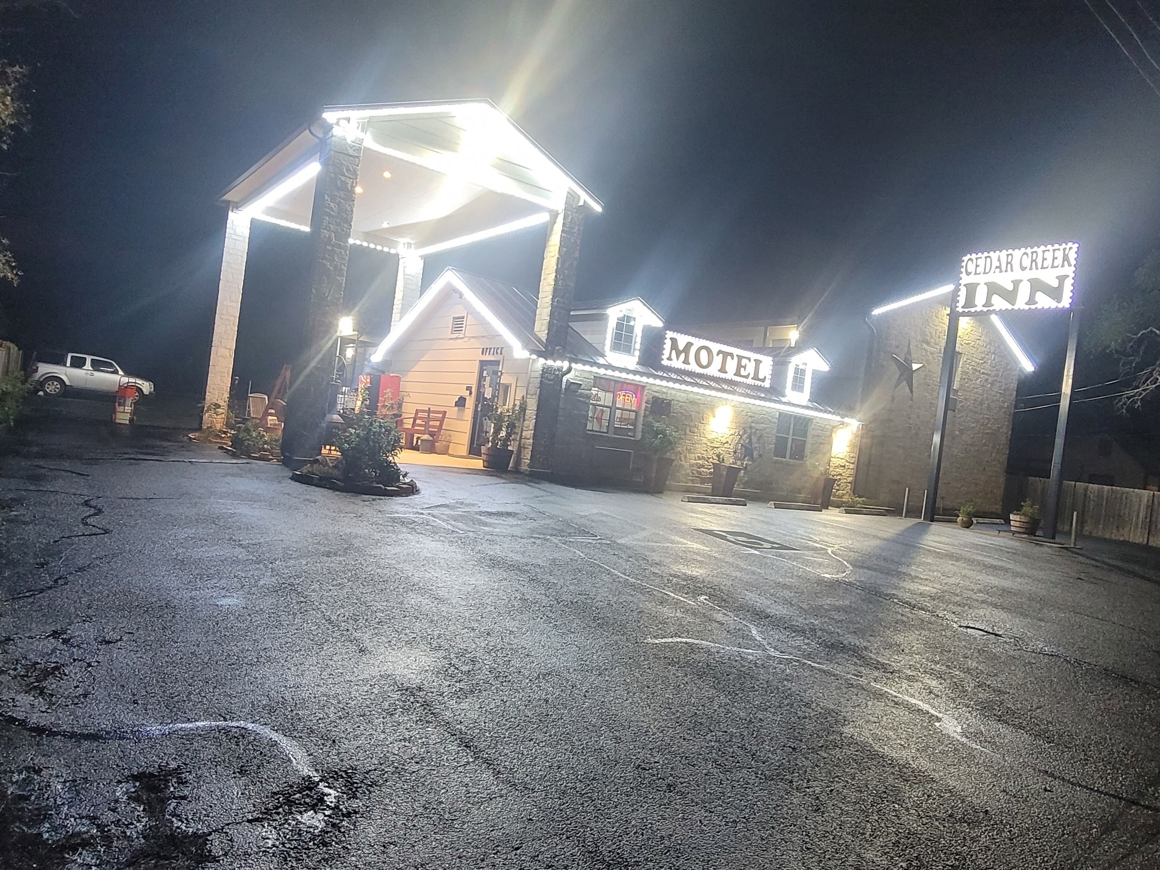 A motel with a prominent 'Motel' sign, a small office building, and a parking lot.