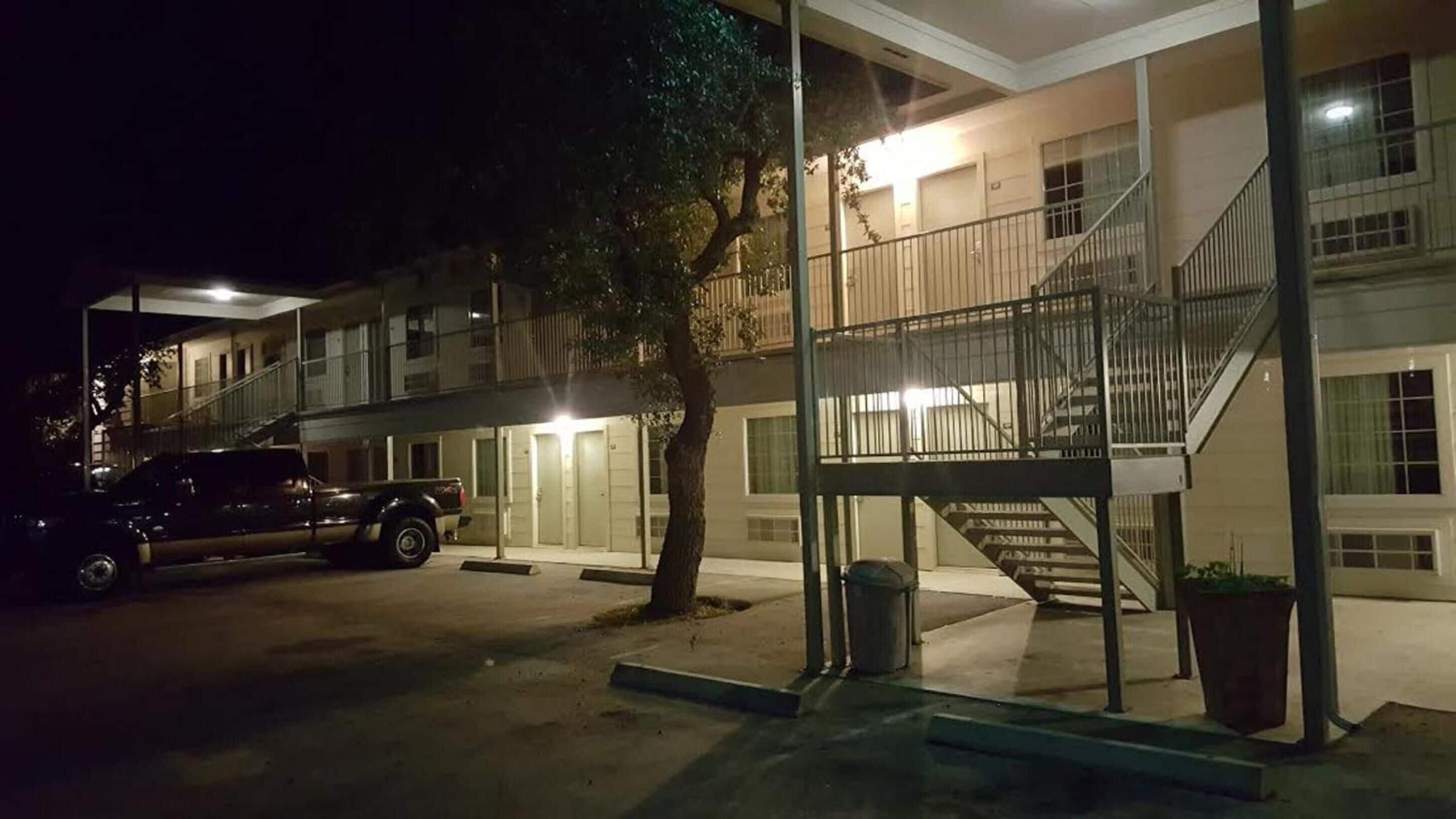 A two-story building with a staircase and a parked truck.