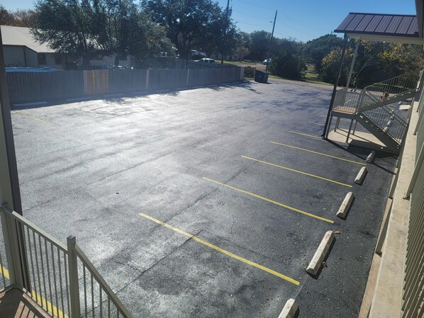 A parking lot with marked spaces and a gated entrance. - Cedar Creek Inn (Bertram)