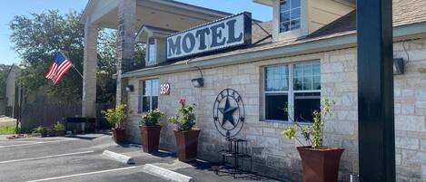 Egy kőhomlokzatú motel, nagy felirattal és egy texasi csillagmotívummal.