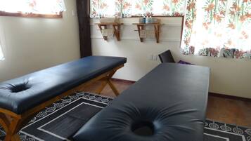Relax with a massage on one of two tables, set against a simple, patterned backdrop.