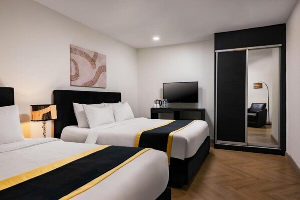 A hotel room with two beds, a flat-screen TV, a desk with a lamp, and a sliding door closet. - Royce Hotel @ Kl Sentral (Kuala Lumpur)