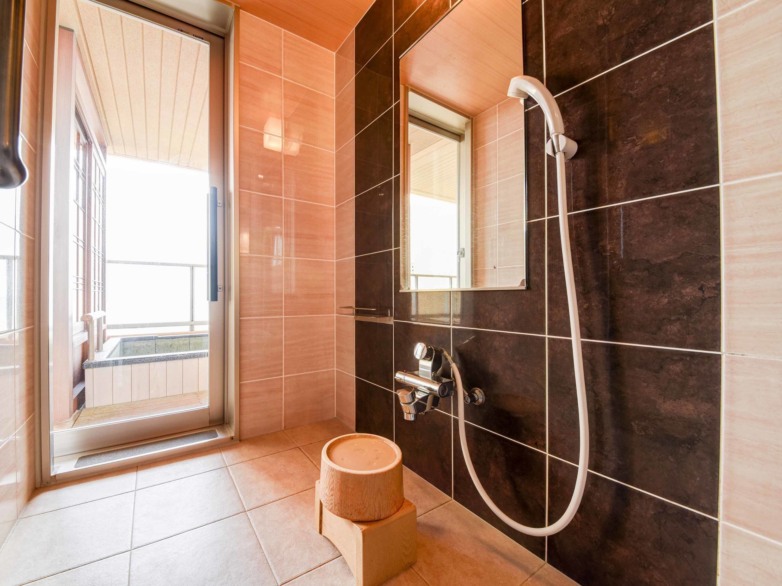 Een moderne badkamer met een douche, toilet en wastafel.