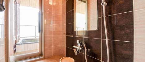 Een moderne badkamer met een douche, toilet en wastafel.