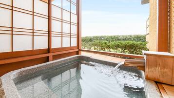 Un jacuzzi con vistas a un jardín y una habitación japonesa tradicional con puertas correderas.