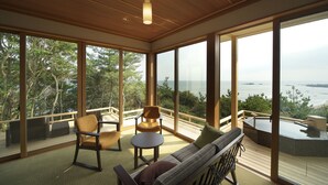 A spacious balcony with a wooden deck, large windows offering a view of the sea, and outdoor seating including a sofa and chairs. - Hotel Bettei Umi To Mori (Choshi)