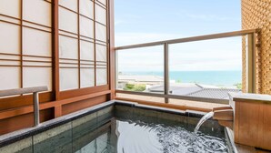 A traditional Japanese-style room with tatami flooring, a wooden sliding door, and a view of the sea through large windows. - Hotel Bettei Umi To Mori (Choshi)