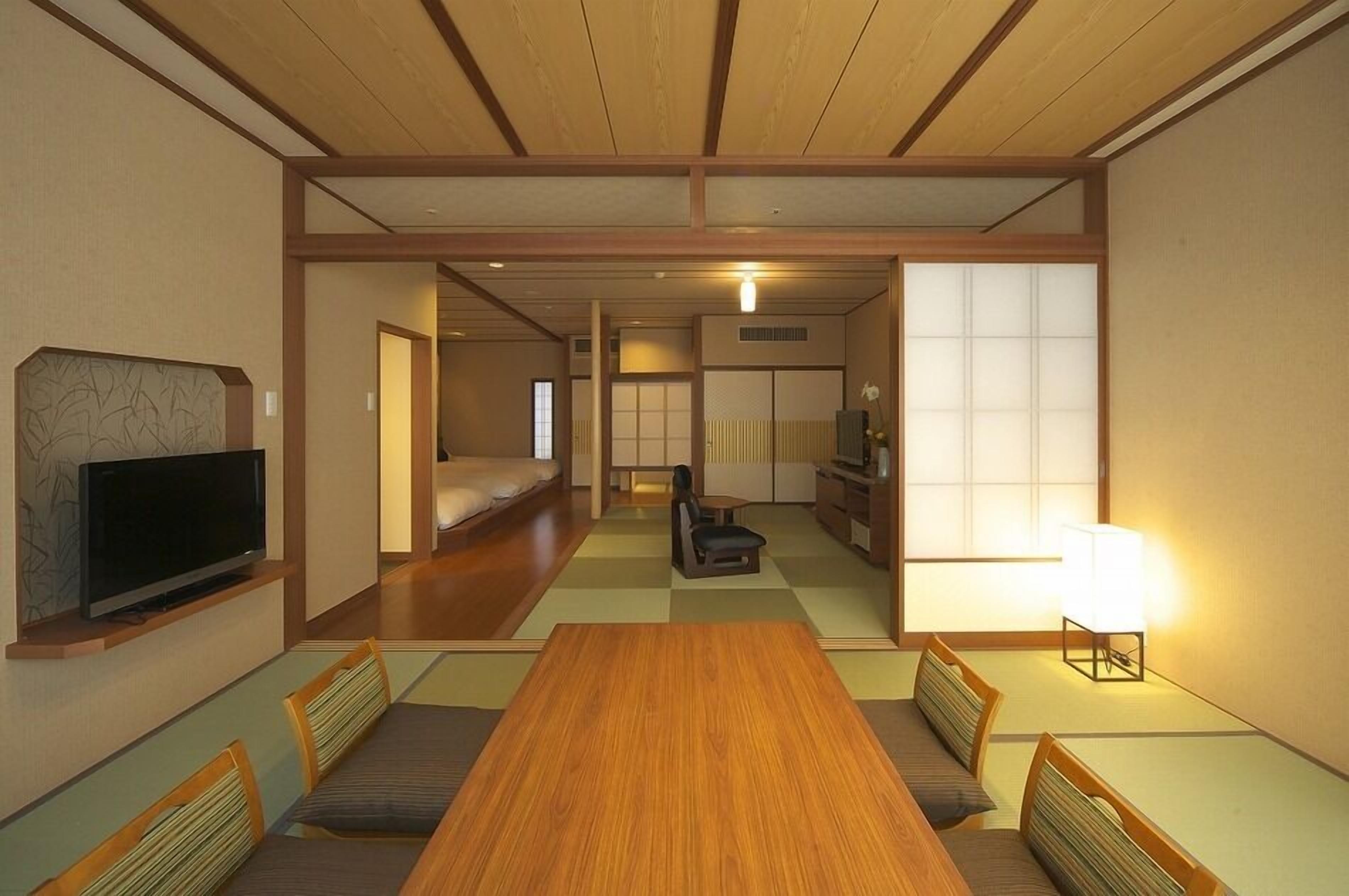 Ein traditioneller japanischer Raum mit Tatami-Boden, niedriger Holzdecke und Schiebetüren.