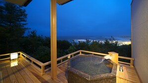 A wooden deck with a hot tub and a view of the ocean at dusk. - Hotel Bettei Umi To Mori (Choshi)