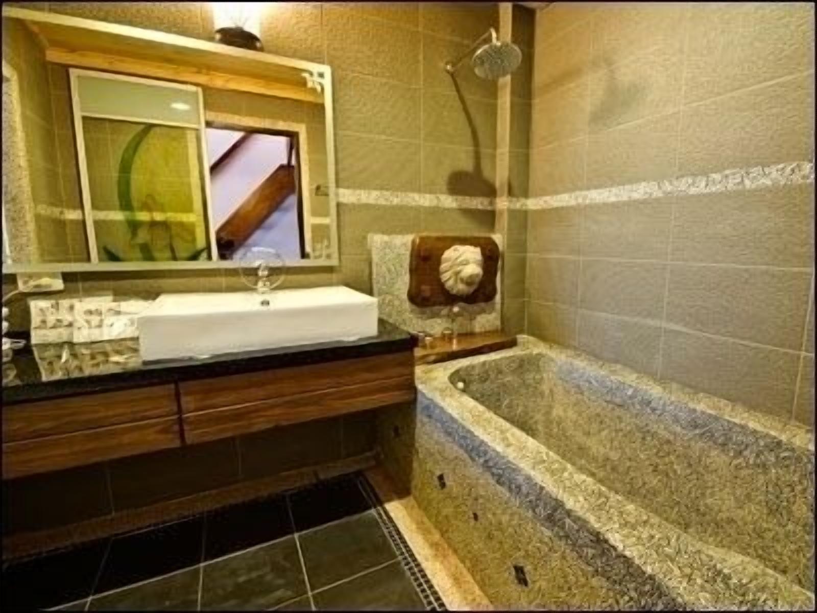 A bathroom with a large bathtub, a wooden vanity, and a mirror above the sink.