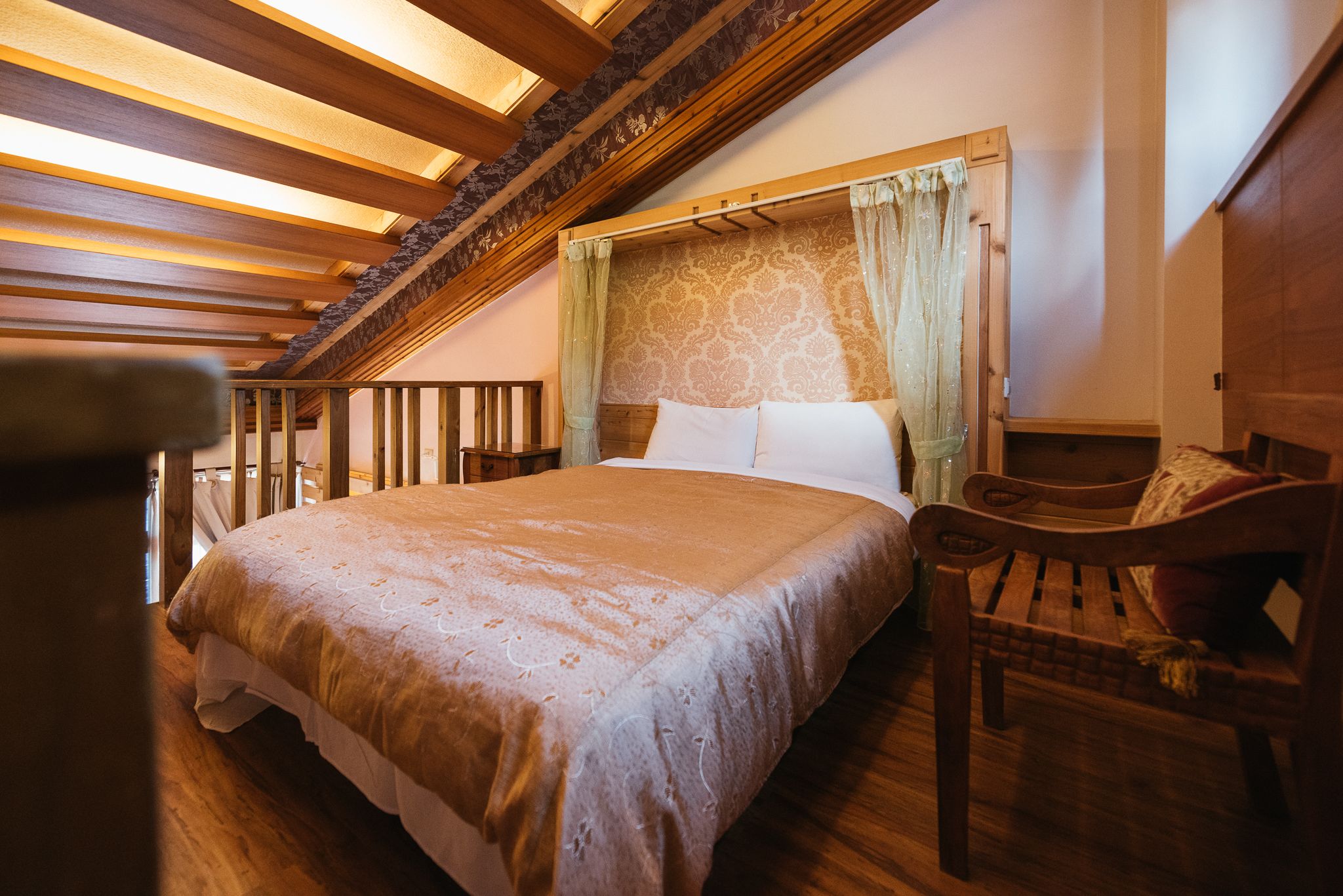 Un dormitorio con una cama grande, cabecera de madera y un banco de madera.