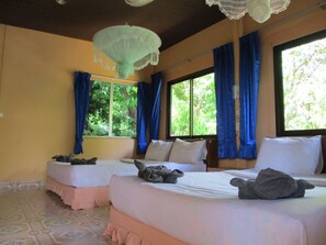 A room with two beds, a patterned floor, and large windows with blue curtains. - Khao Sok Island Resort and Spa (Phanom)