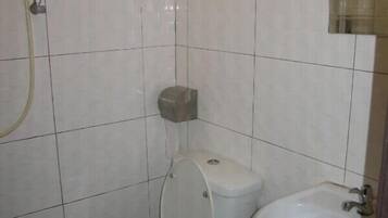 Un baño pequeño con inodoro, bidé y lavamanos.