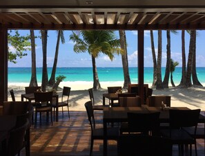 A beachside restaurant with outdoor seating, palm trees, and a view of the ocean. - 357 Boracay (Boracay Island)
