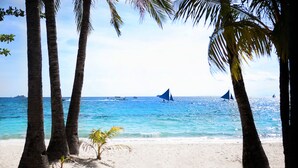 A beach with palm trees and boats on the water. - 357 Boracay (Boracay Island)