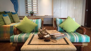 A living room with a sofa, armchairs, a coffee table, and a window with blinds. - 357 Boracay (Boracay Island)