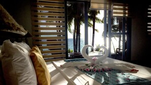 A hotel room with a bed, pillows, a heart-shaped decoration, and a view of the ocean through large windows. - 357 Boracay (Boracay Island)