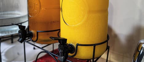 Two glass containers with metal lids, one with a yellow liquid and the other with a clear liquid, both on a metal stand.