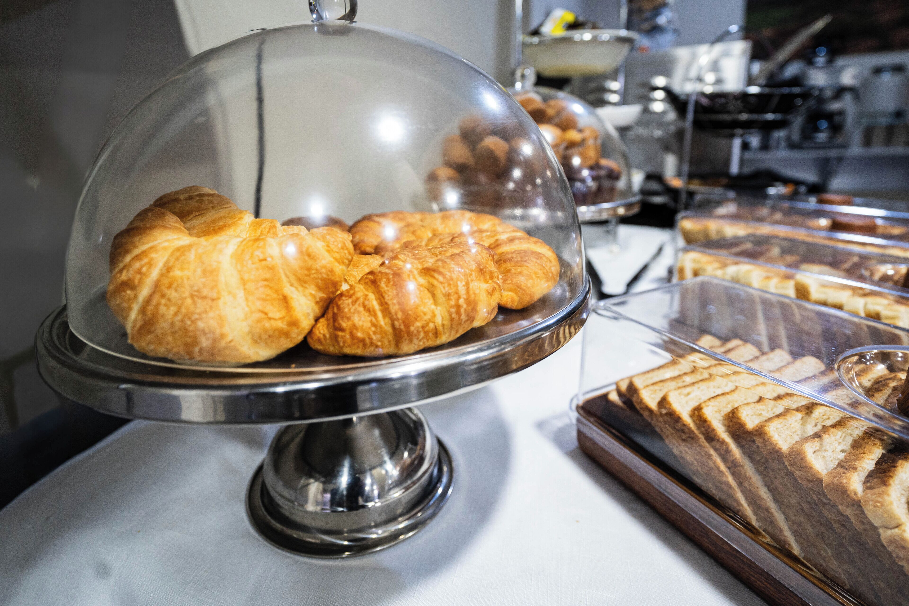 A bakery display with croissants and bread.