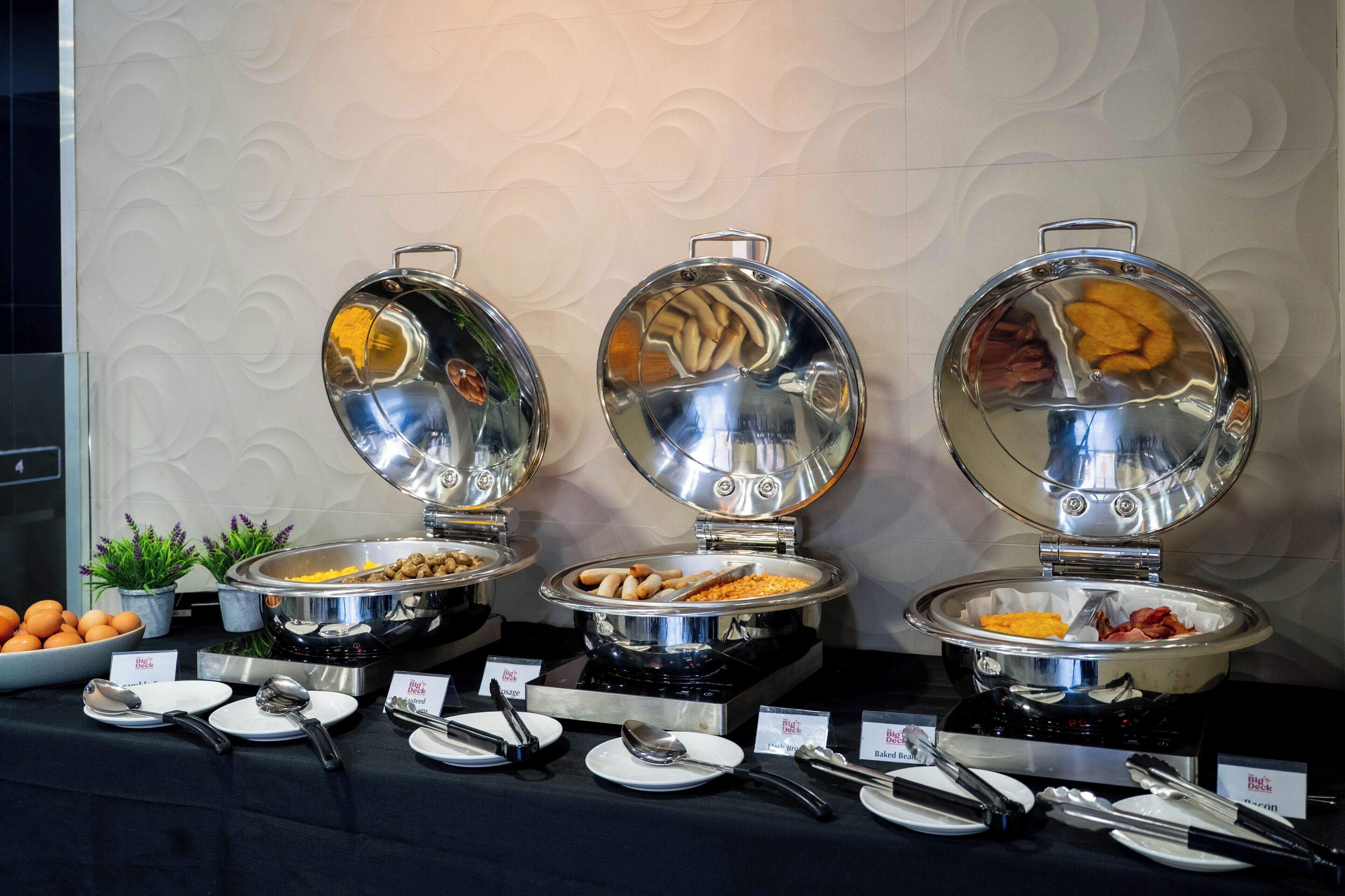 Drei Speisebuffets mit Speisen und Besteck.