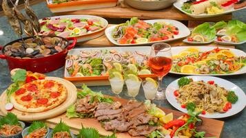 Variedad de platos que incluyen mariscos, ensaladas y pizza, lo que sugiere un menú diverso.