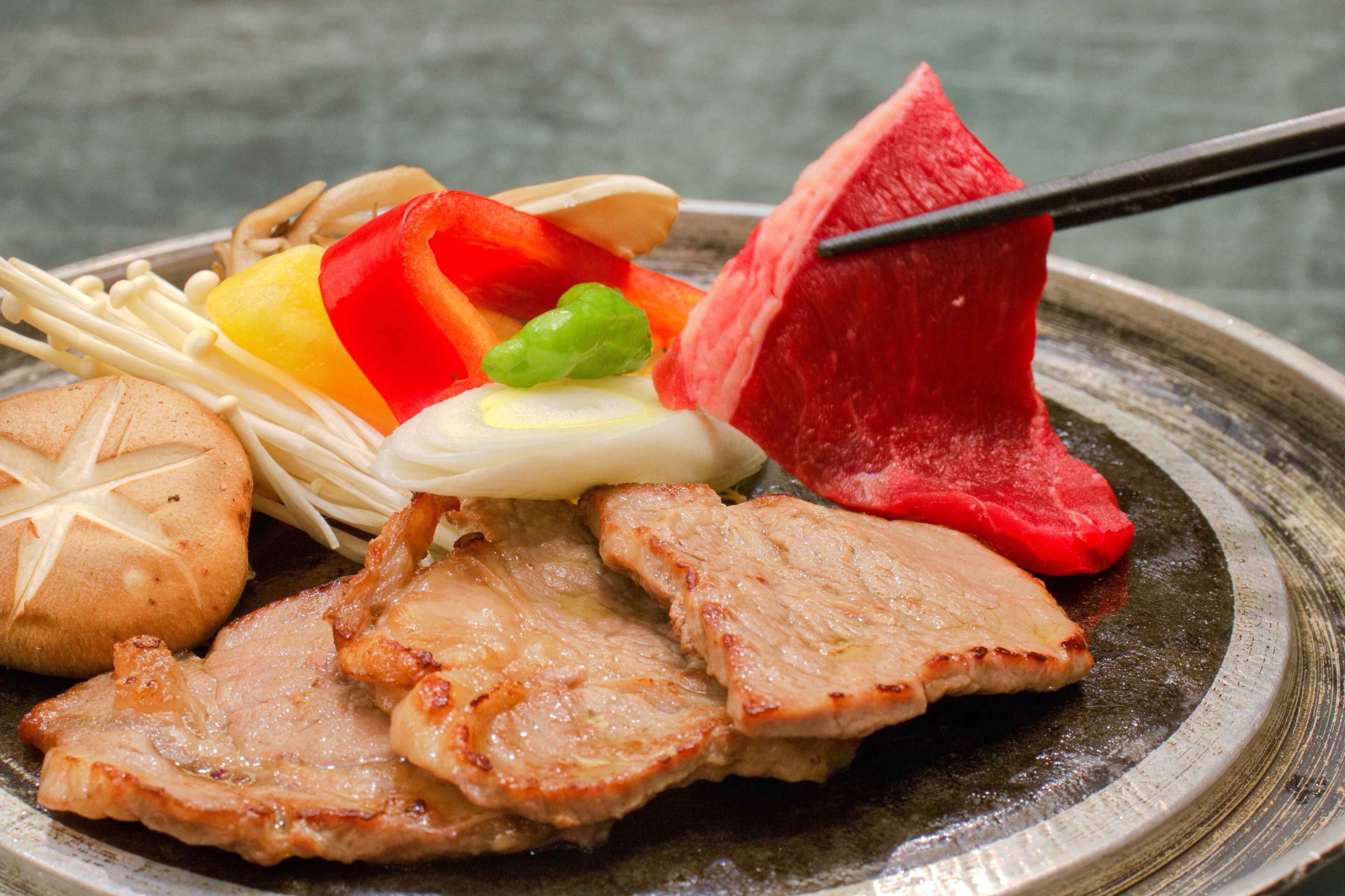 A plate of food with various items including meat, vegetables, and noodles.